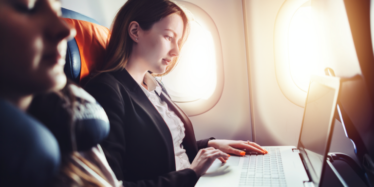 a female working on a laptop in an airplane