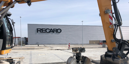 A digger in front of recaro's hq, being used to build an extension