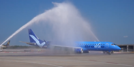 a breeze airways jet receiving a water cannon salute at tampa airport