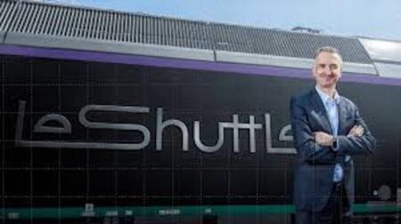 Yann Leriche, CEO of Getlink, parent company of Eurotunnel, next to a train with the the Eurotunnel LeShuttle rebranding