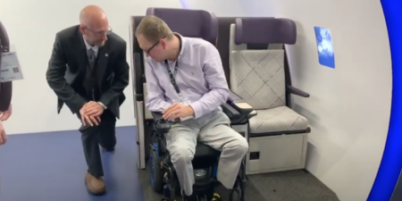 John Morris moving his power wheelchair into the Air4All aircraft seat