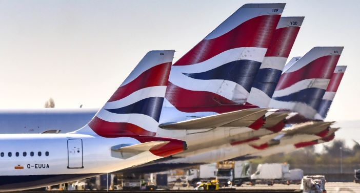 Tail fins of British Airways jets lined up at London Heathrow Airport