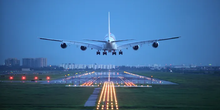 A four-engined airplane taking off at dusk
