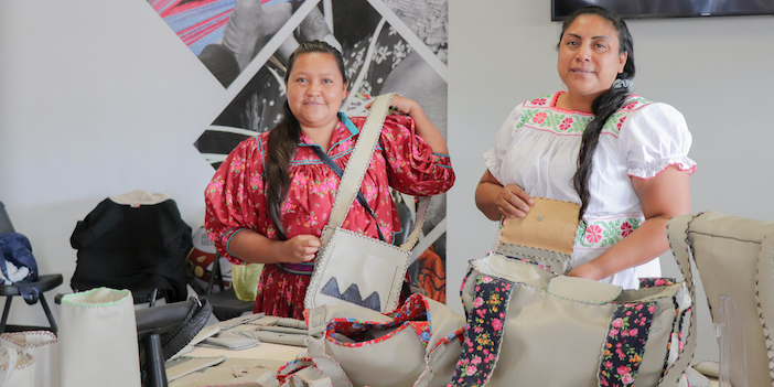 2 women from the the Tarahumara tribe showing their bags in the shop
