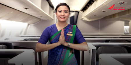A female Air India cabin crew member welcoming guests into the airline's new Airbus A350 aircraft cabin