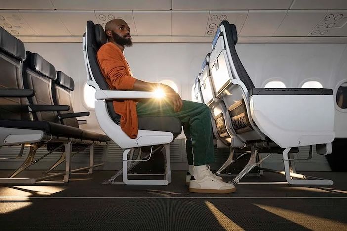 A male passenger relaxing in an Alaska Airlines premium class seat