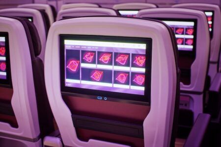 A seatback entertainment screen in a plane showing options for dementia-friendly films