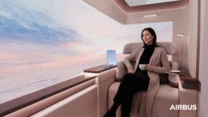 A smartly dressed female passenger sitting in a beige leather seat with virtual panoramic windows wraping around the corner behind her
