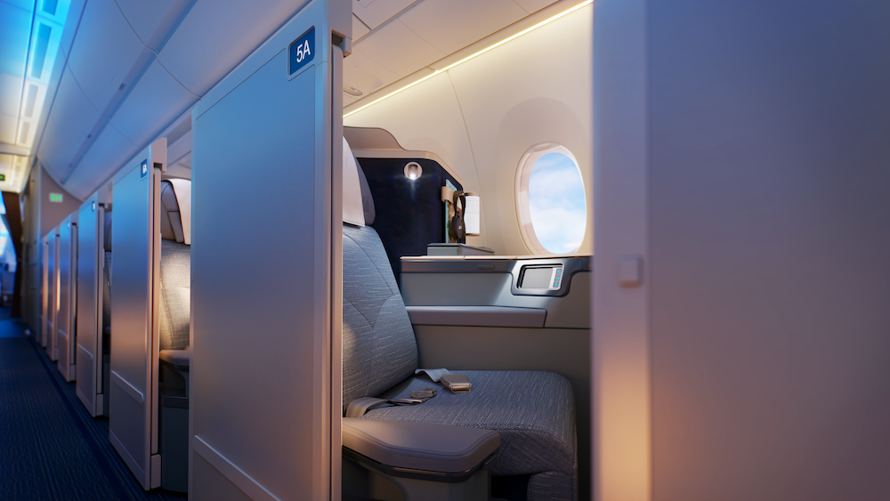 PAL's A350-1000 business class seat with privacy partition, showing aisle access, personal window, and modern gray upholstery in cabin with blue ambient lighting"
