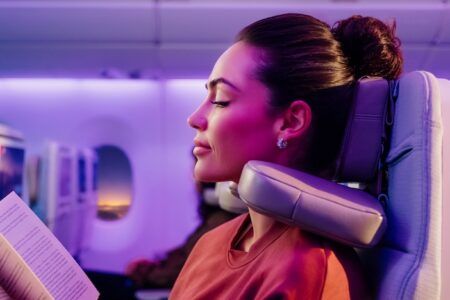 A female passenger resting comfortably with the Emirates U-Dream headrest adjusted around her neck